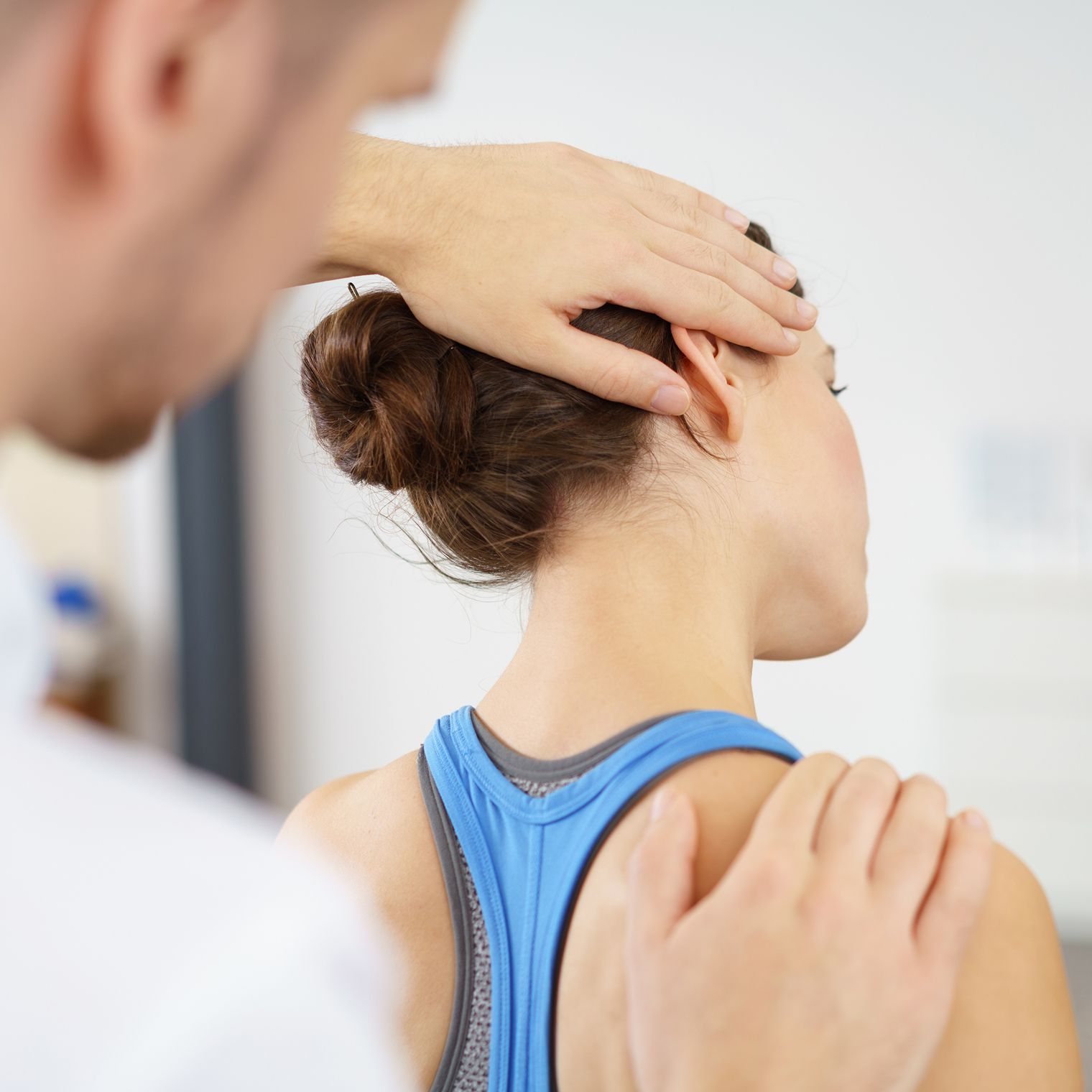 Physiotherapeut behandelt Nackenverspannungen bei einer Patientin